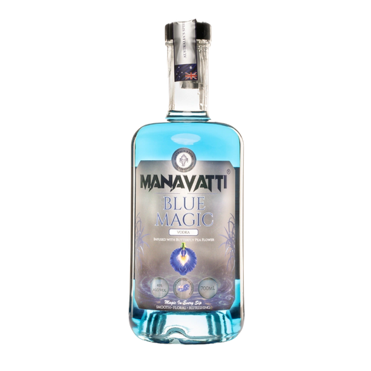 A bottle of Manavatti Blue Magic Vodka on a solid white background. The bottle is made of clear glass, showing a vibrant blue liquid inside.